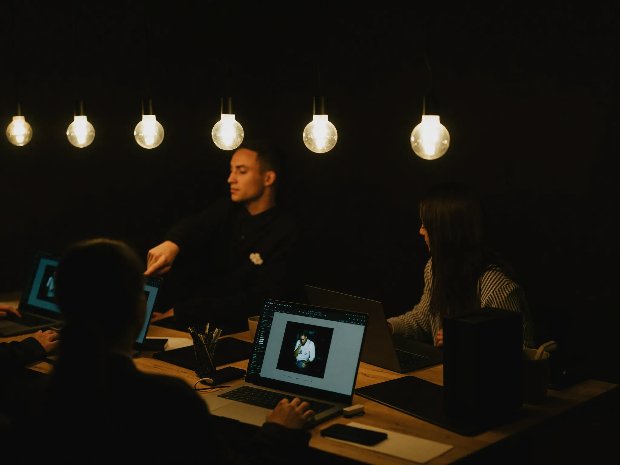 Team working together on laptops in a warm studio space